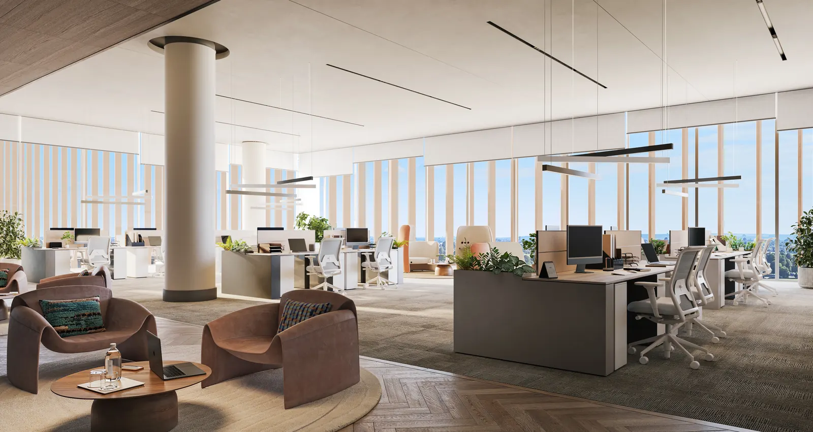 Open-plan studio with workstations and a lounge corner by full-height glazing
